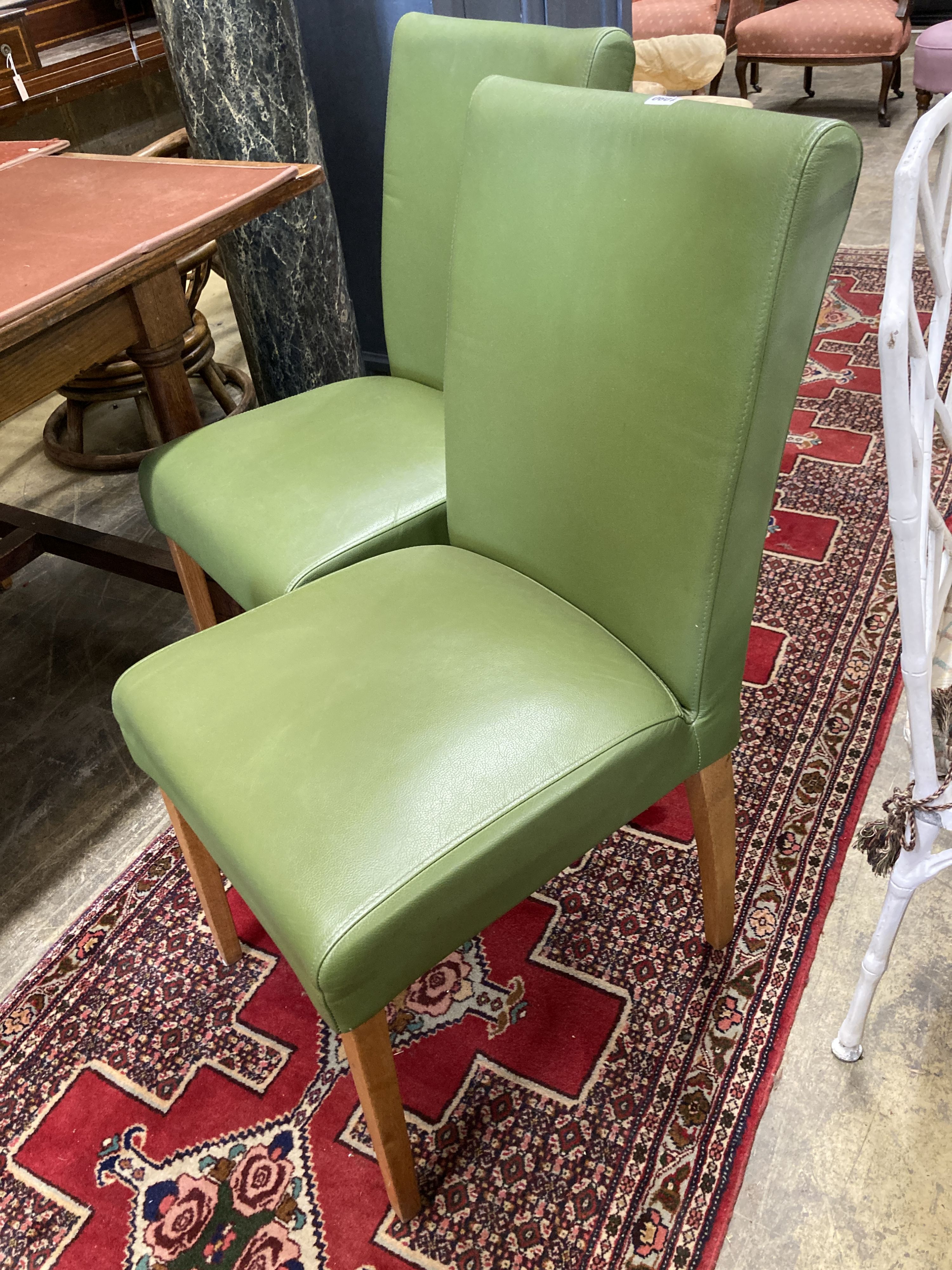 A set of eight contemporary oak and green leather dining chairs, width 45cm, depth 50cm, height 95cm